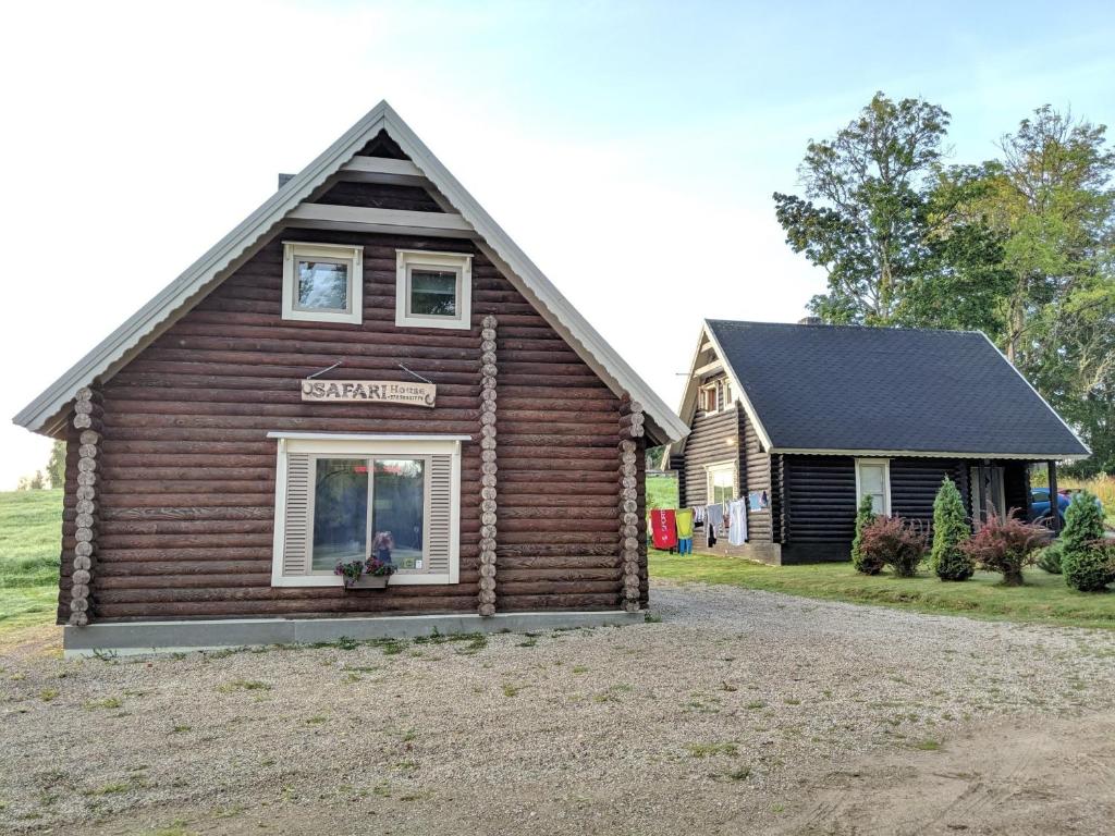 Cabaña de madera con ventana y casa en Safari House en Otepää