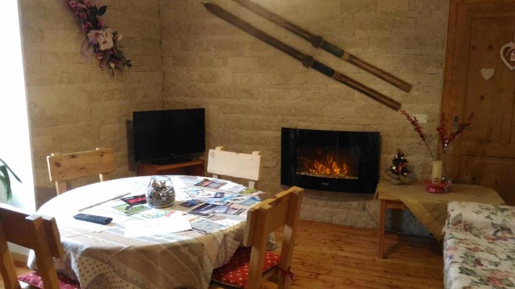 a living room with a table and a fireplace at Alloggio Castello Tesino in Castello Tesino