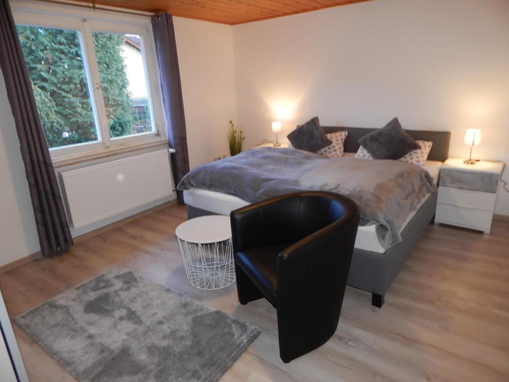 1 dormitorio con 1 cama, 1 silla y 1 ventana en Ferienwohnung Vogl, en Drachselsried
