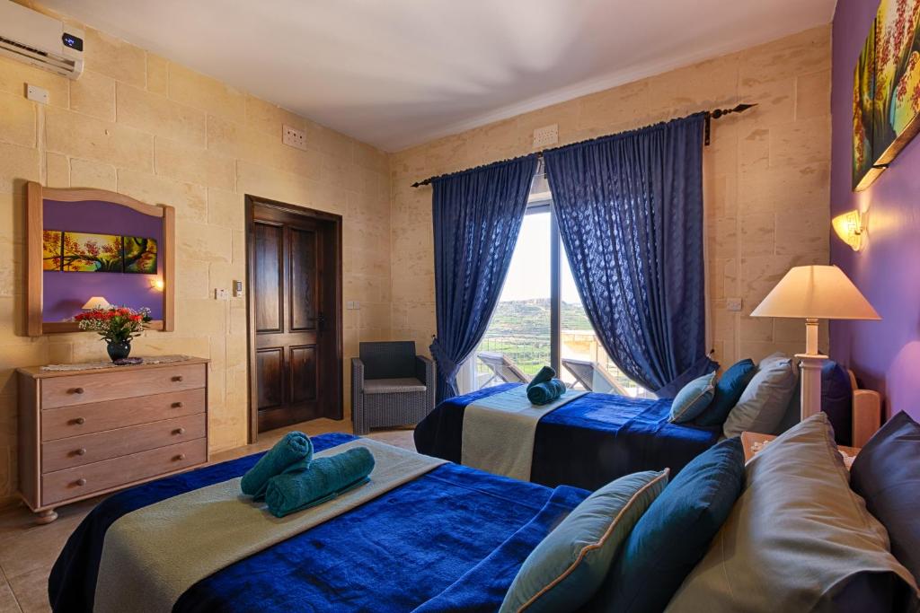 a hotel room with two beds and a couch at Ghajn Damma in Xagħra