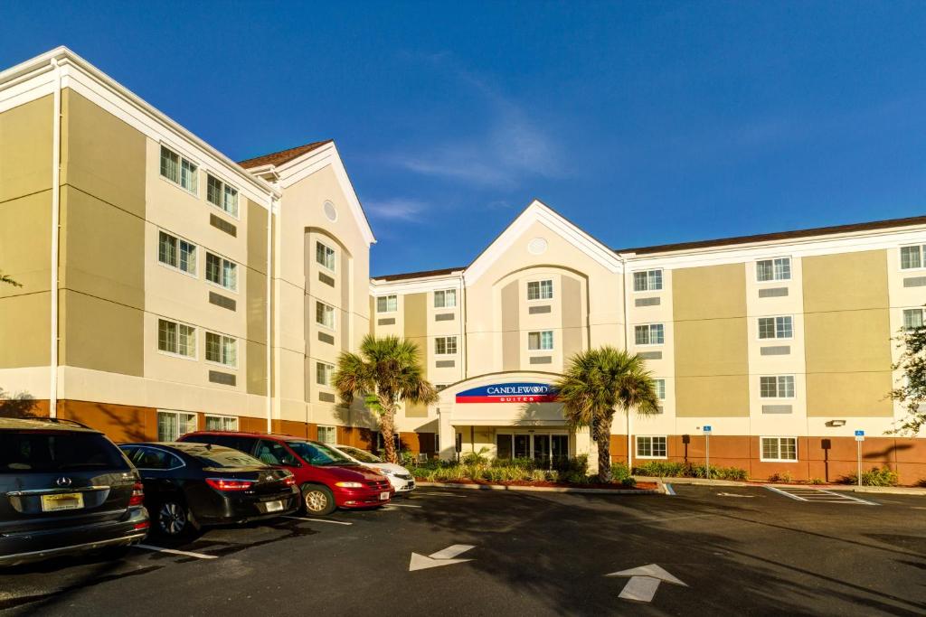 um grande edifício com carros estacionados num parque de estacionamento em Candlewood Suites Fort Myers Interstate 75, an IHG Hotel em Fort Myers