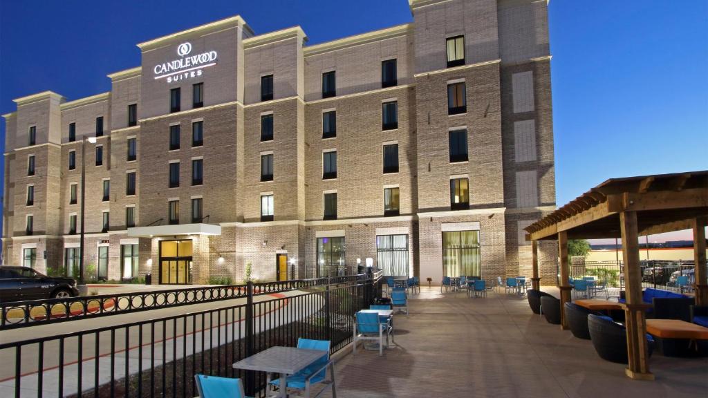 a large building with blue chairs in front of it at Candlewood Suites - Frisco, an IHG Hotel in Frisco