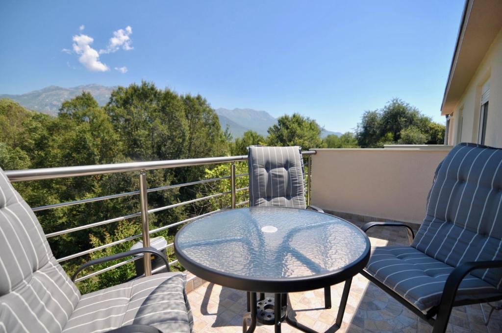 a patio with two chairs and a table on a balcony at NEÐO Apartments Brda in Tivat
