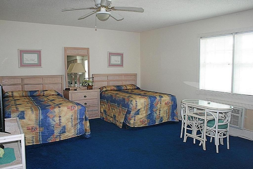 1 Schlafzimmer mit 2 Betten, einem Tisch und einem Spiegel in der Unterkunft 805L home in Calabash