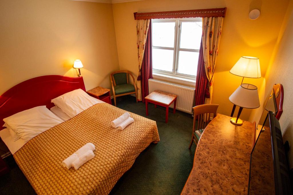a bedroom with a bed with two towels on it at Tysfjord Hotel in Storjord I Tysfjord