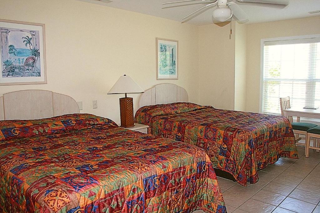 ein Hotelzimmer mit 2 Betten und einem Tisch in der Unterkunft Studio Brunswick Plantation Villa 2404L in Calabash