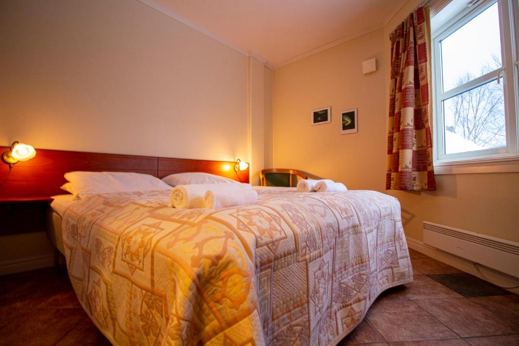 a bedroom with a large bed and a window at Tysfjord Hotel in Storjord I Tysfjord