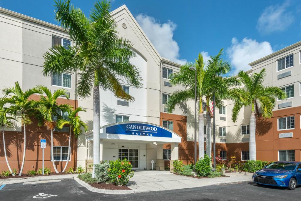 an image of the front of a hotel with palm trees at Candlewood Suites Fort Myers/Sanibel Gateway, an IHG Hotel in Fort Myers