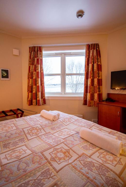 a bedroom with a large bed with a window at Tysfjord Hotel in Storjord I Tysfjord