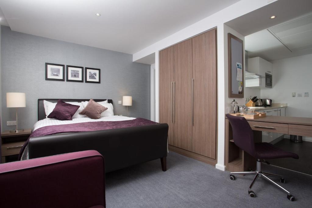 a bedroom with a bed and a desk and a desk at Staybridge Suites Birmingham, an IHG Hotel in Birmingham
