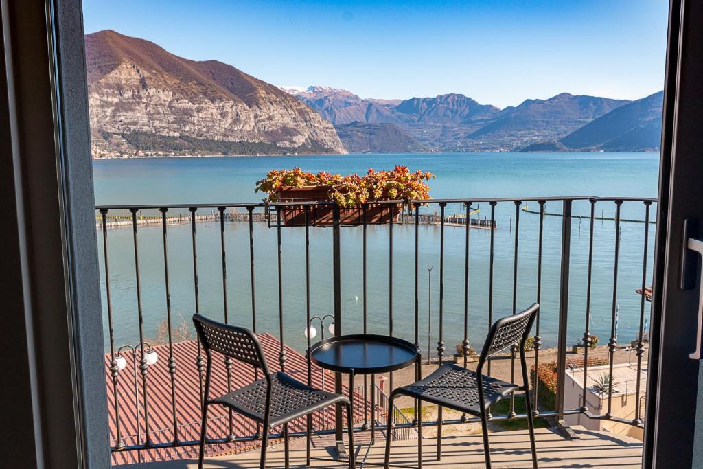 a balcony with a table and chairs and a view of the water at Locanda del Lago Rosmunda in Clusane sul Lago