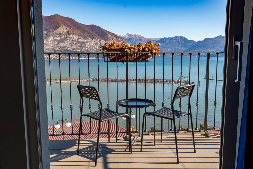 uma varanda com cadeiras e uma mesa com vista para a água em Locanda del Lago Rosmunda em Clusane sul Lago