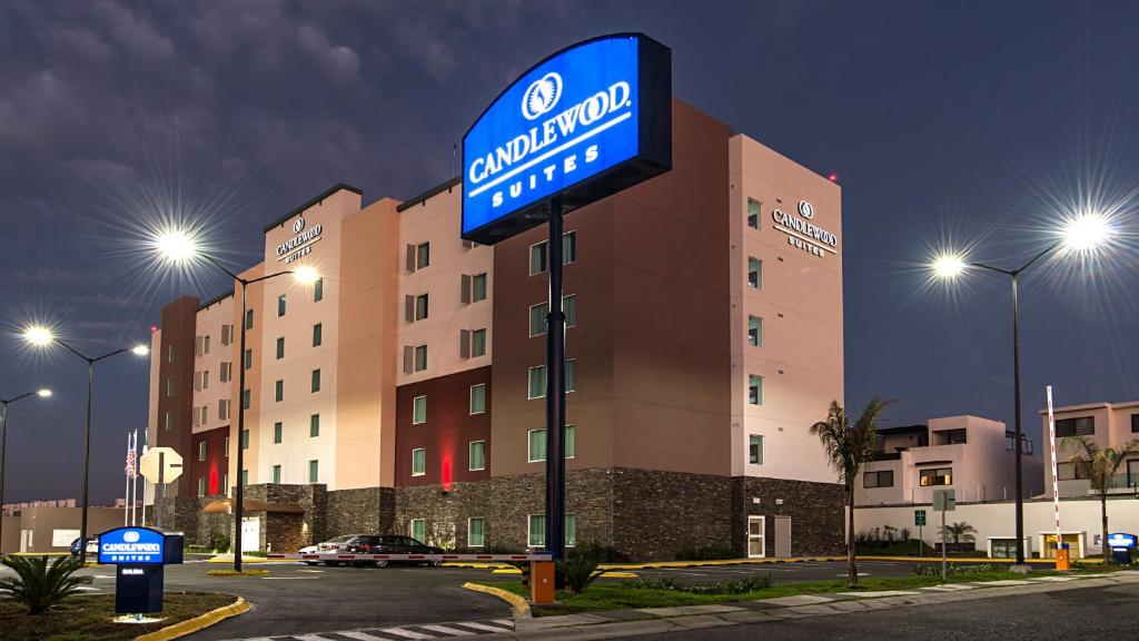 una señal de hotel frente a un edificio por la noche en Candlewood Suites - Queretaro Juriquilla, an IHG Hotel, en Querétaro