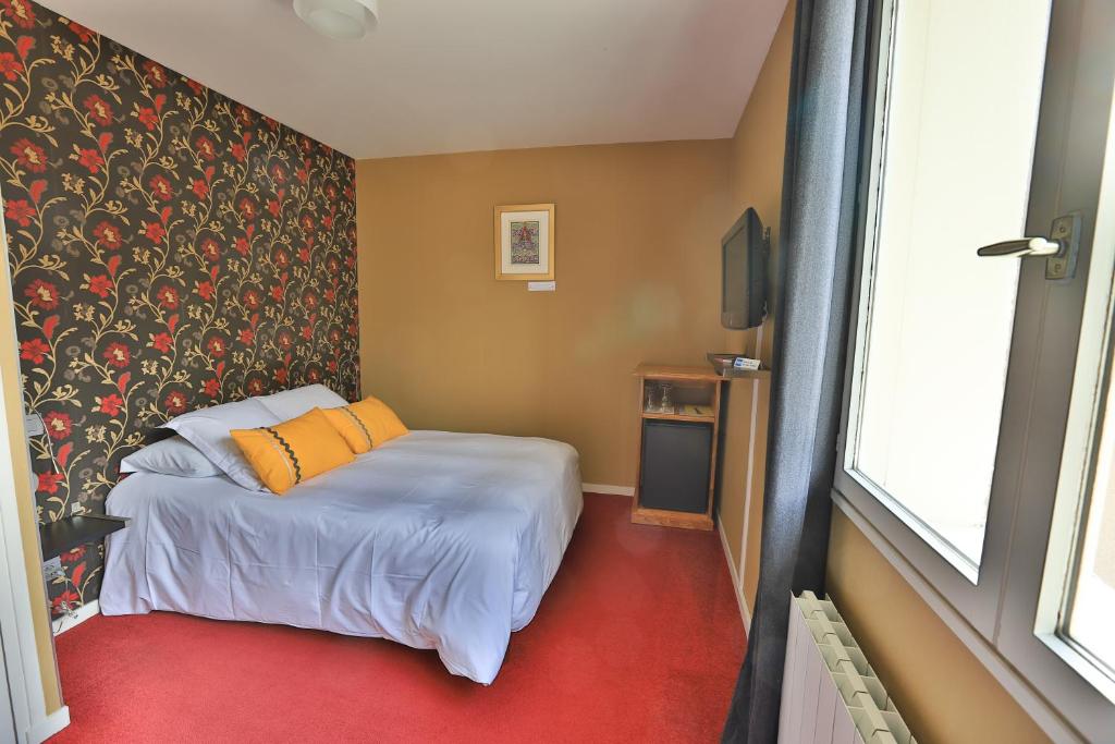 Postel nebo postele na pokoji v ubytování Logis Hotel Des Grands Vins