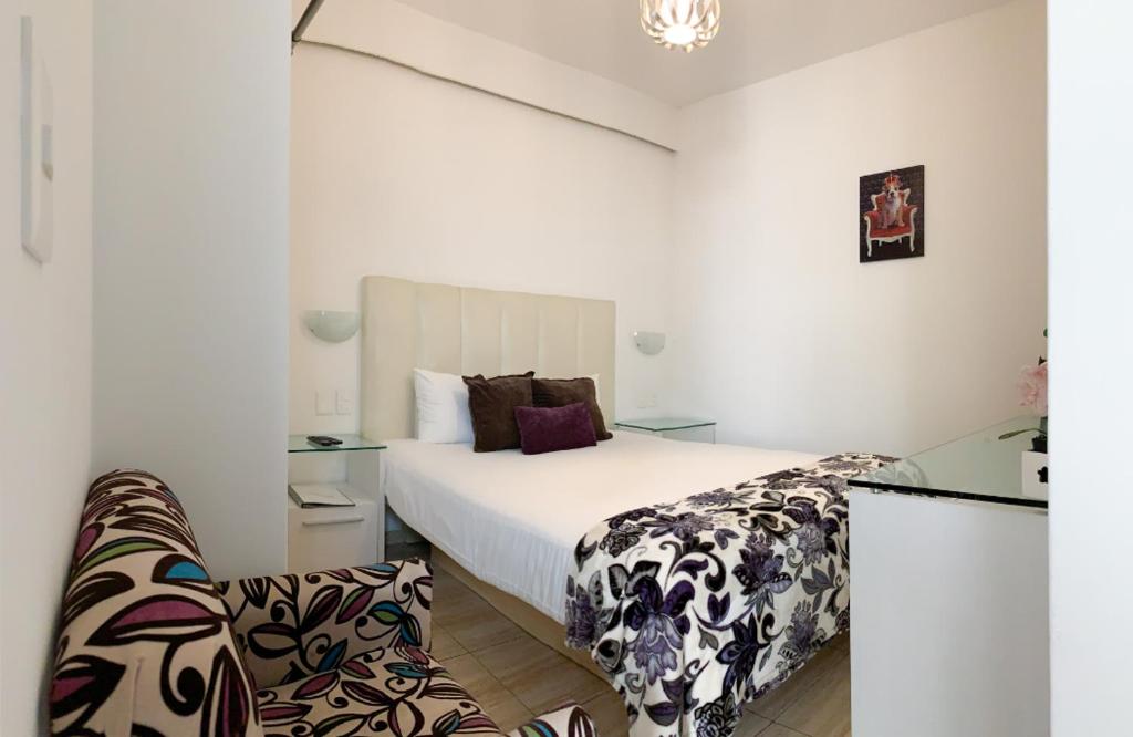 1 dormitorio con 1 cama blanca grande y 1 silla en Condesa 185 en Ciudad de México
