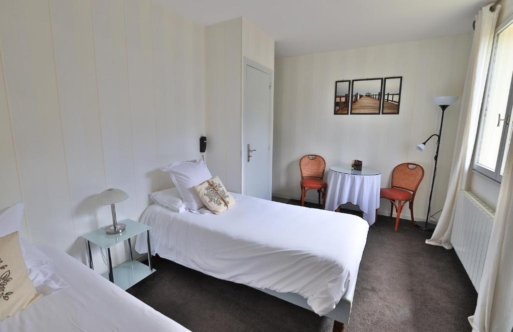 Postel nebo postele na pokoji v ubytování Logis Hotel Des Grands Vins