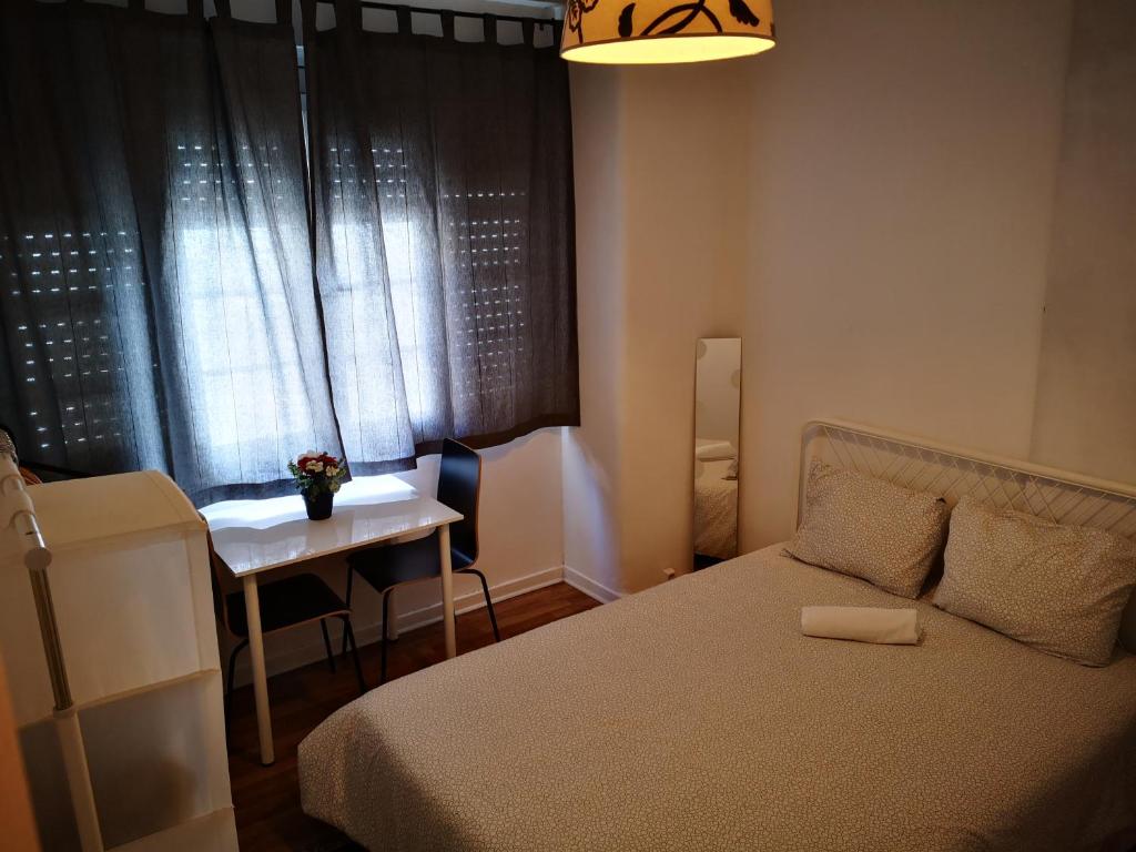 - une chambre avec un lit, une table et une fenêtre dans l'établissement PARAISO Da PENHA, à Lisbonne