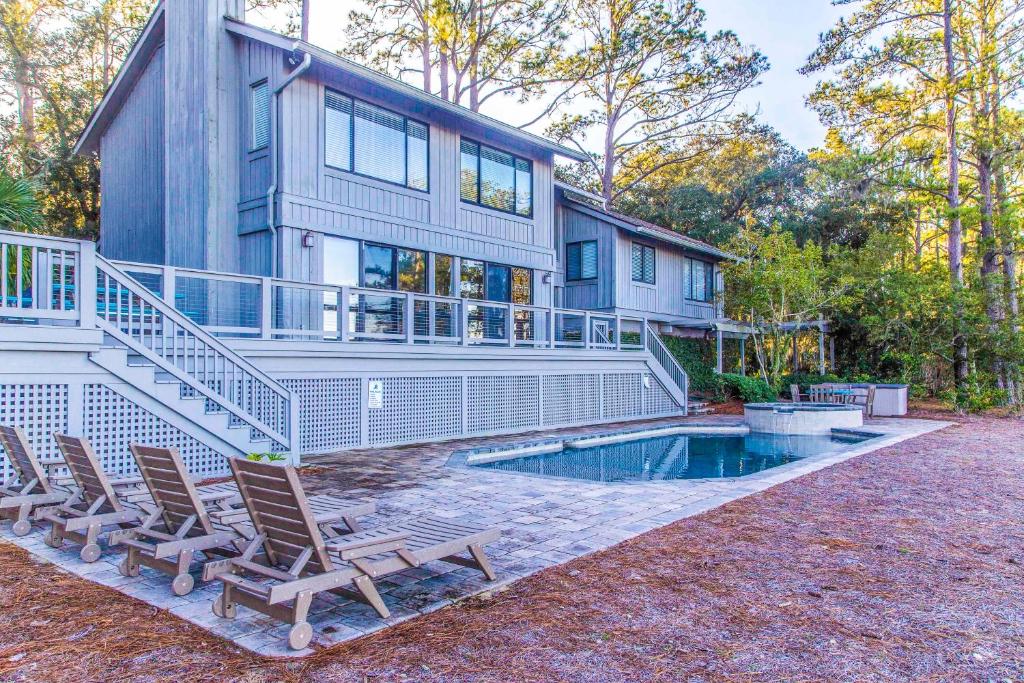 ein Haus mit Stühlen und einem Pool davor in der Unterkunft 18 Wren Drive in Hilton Head Island