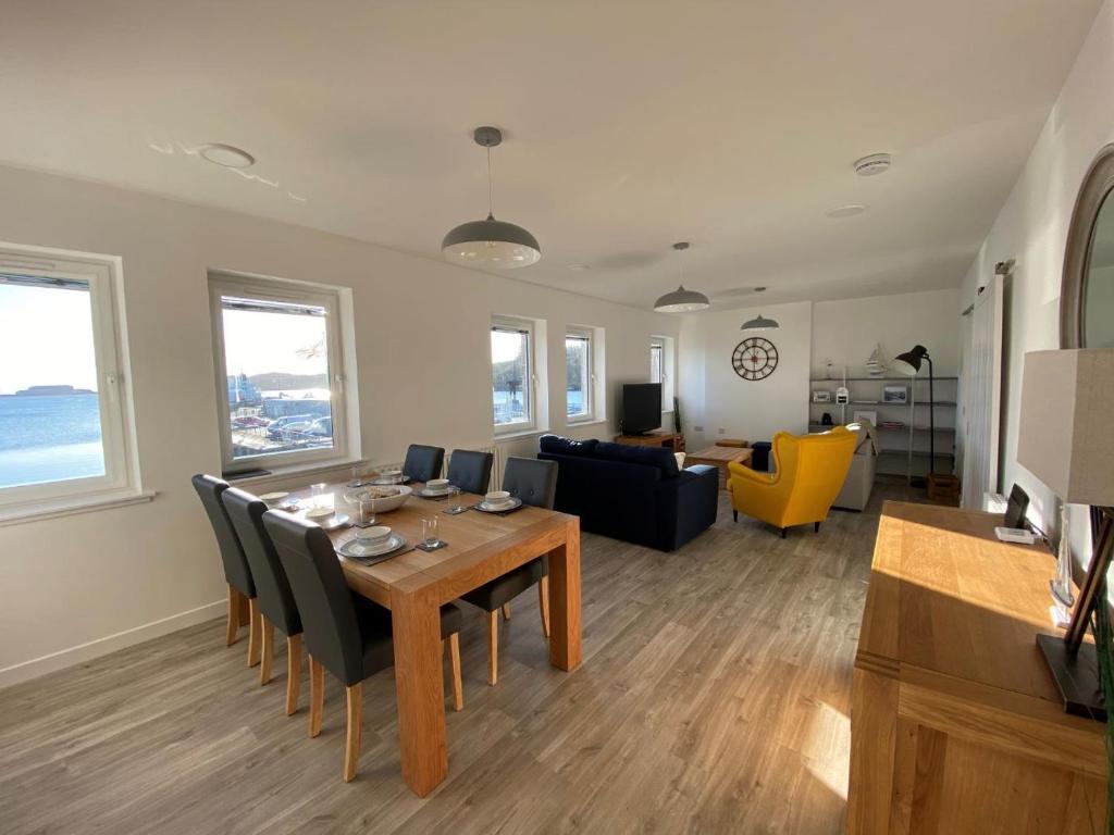 a dining room and living room with a table and chairs at 4 South Beach Stornoway in Stornoway