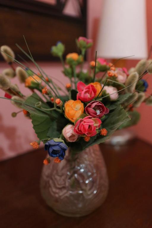 a glass vase with flowers in it on a table at Nafpaktos Apartments in Nafpaktos