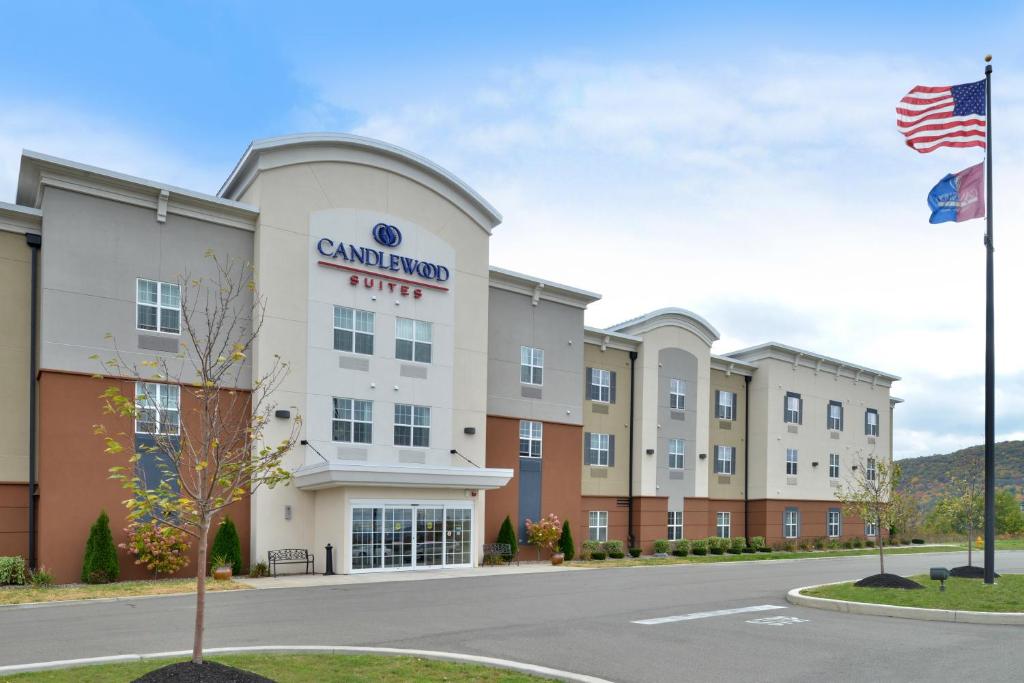 an exterior view of a grand hotel with an american flag at Candlewood Suites Elmira Horseheads by IHG in Horseheads
