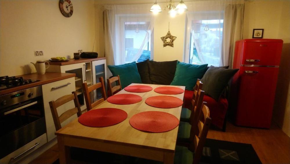 a kitchen with a table with four red mats on it at Prázdninový dům Matterhorn in Železná Ruda