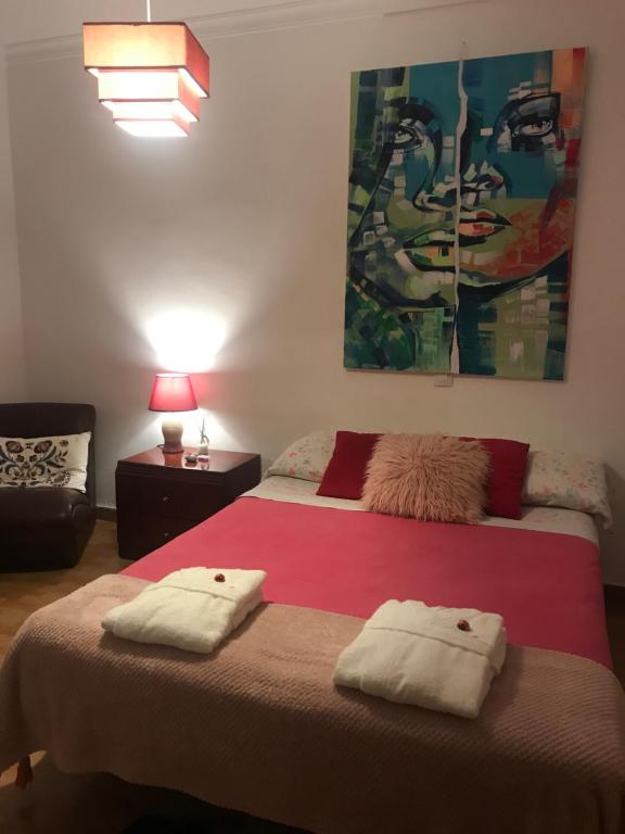 una camera da letto con un grande letto con due cuscini sopra di Tranquila habitación a Las Palmas de Gran Canaria