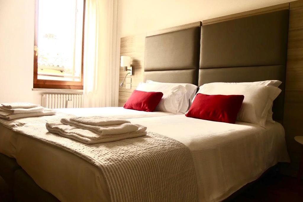 a bedroom with a large white bed with red pillows at 3 Amici al Teatro in Verona