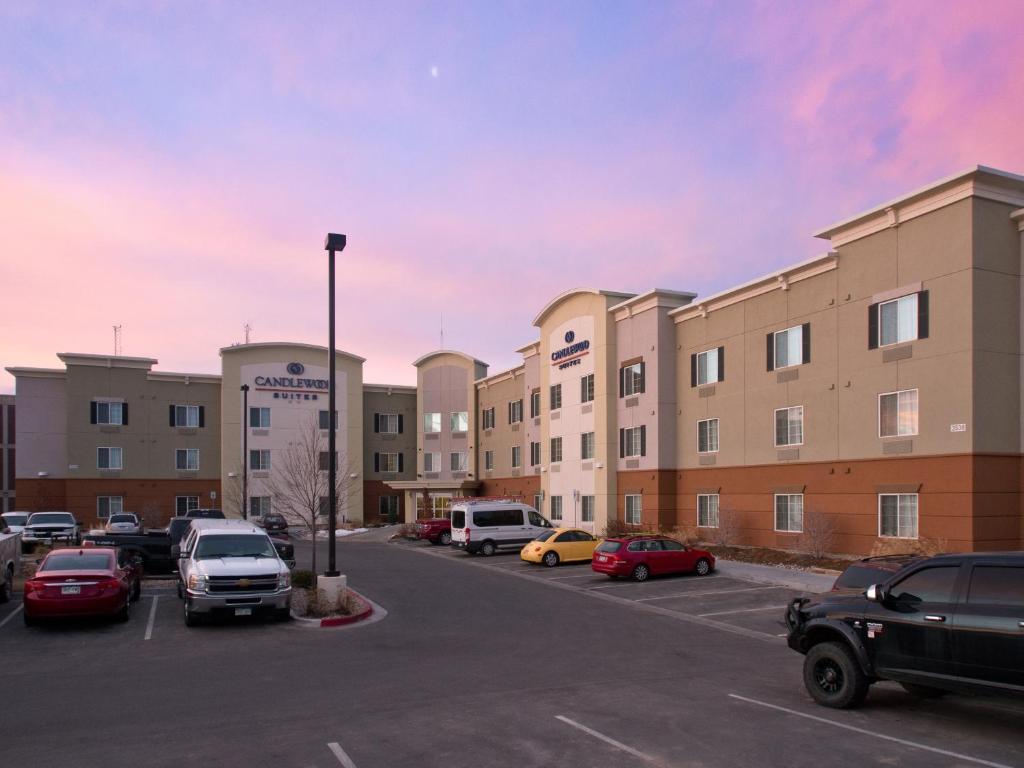 un estacionamiento con autos estacionados frente a un edificio en Candlewood Suites Greeley, an IHG Hotel, en Greeley