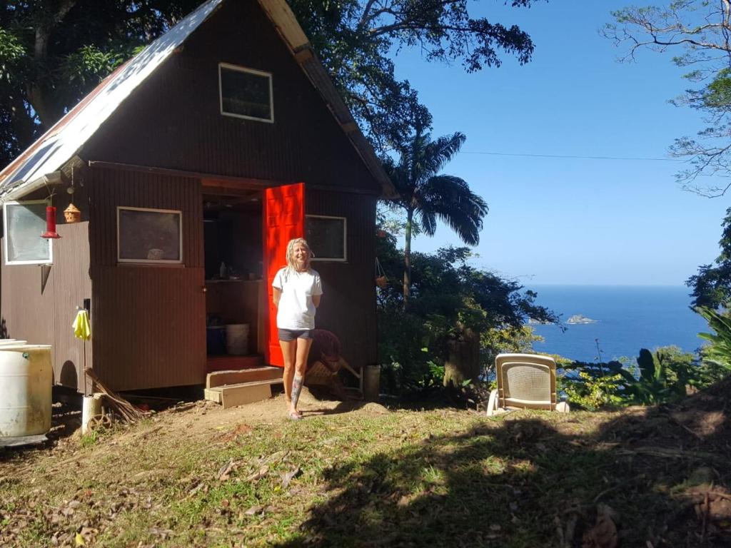a woman is standing outside of a house at Tony's Offgrid Cabin Getaway in Scarborough