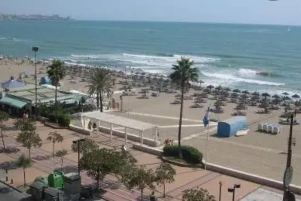 una spiaggia con molte sedie e l'oceano di BEAUTIFUL PENTHOUSE SOLARIUM IN BOLICHES BEACH a Fuengirola