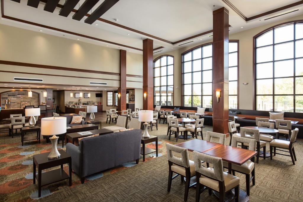 hol hotelowy ze stołami, krzesłami i oknami w obiekcie Staybridge Suites - Columbus Polaris, an IHG Hotel w mieście Flint