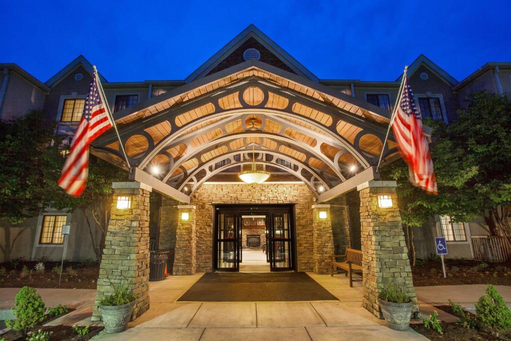 un edificio con dos banderas americanas delante de él en Staybridge Suites Corning, an IHG Hotel, en Corning