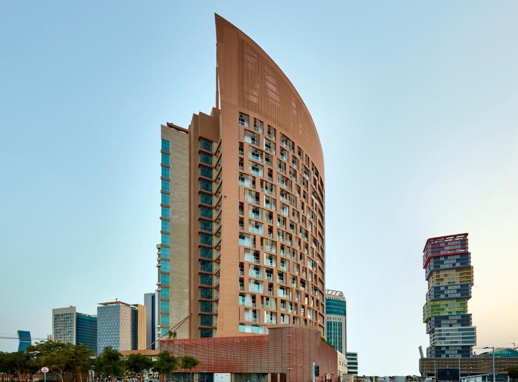 a tall building in the middle of a city at Staybridge Suites - Doha Lusail, an IHG Hotel in Doha