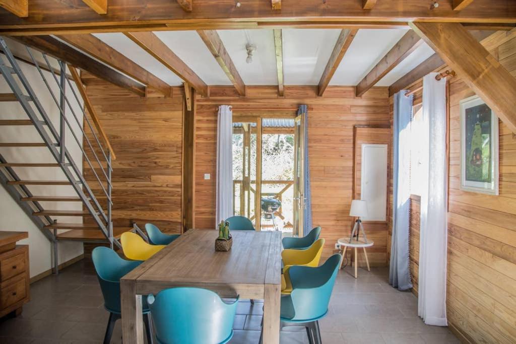 ein Esszimmer mit einem Holztisch und blauen Stühlen in der Unterkunft Barbadine in La Plaine des Cafres