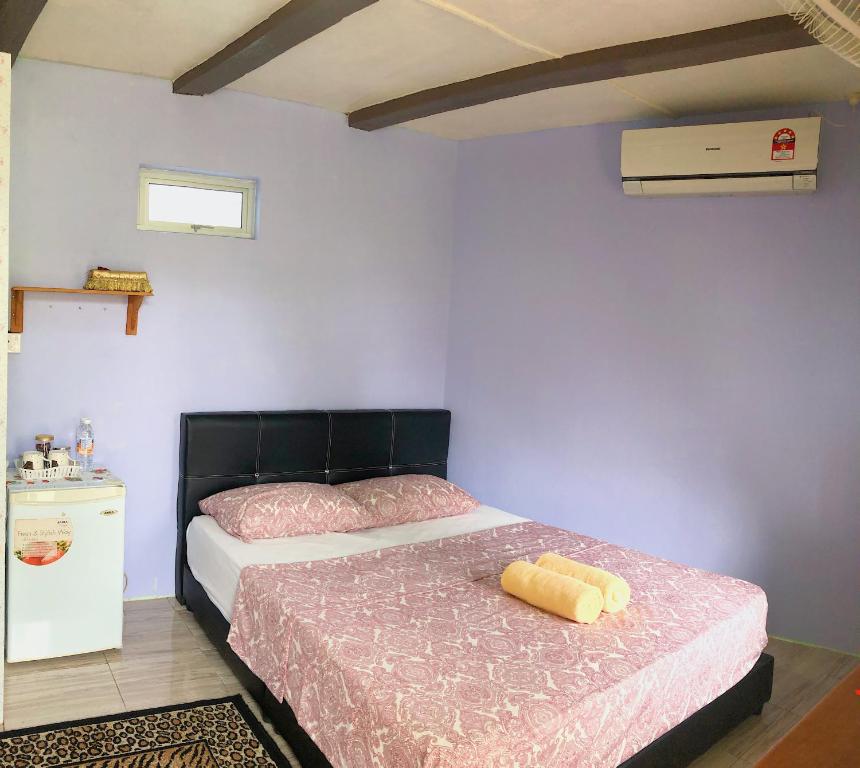 1 dormitorio con 1 cama con cabecero negro en Merdeka Guest House 2, en Kuching