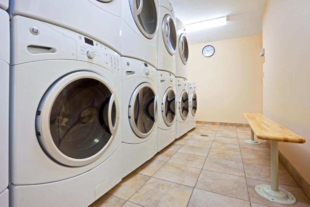 a row of white washing machines in a laundry room at Candlewood Suites NYC -Times Square, an IHG Hotel in New York