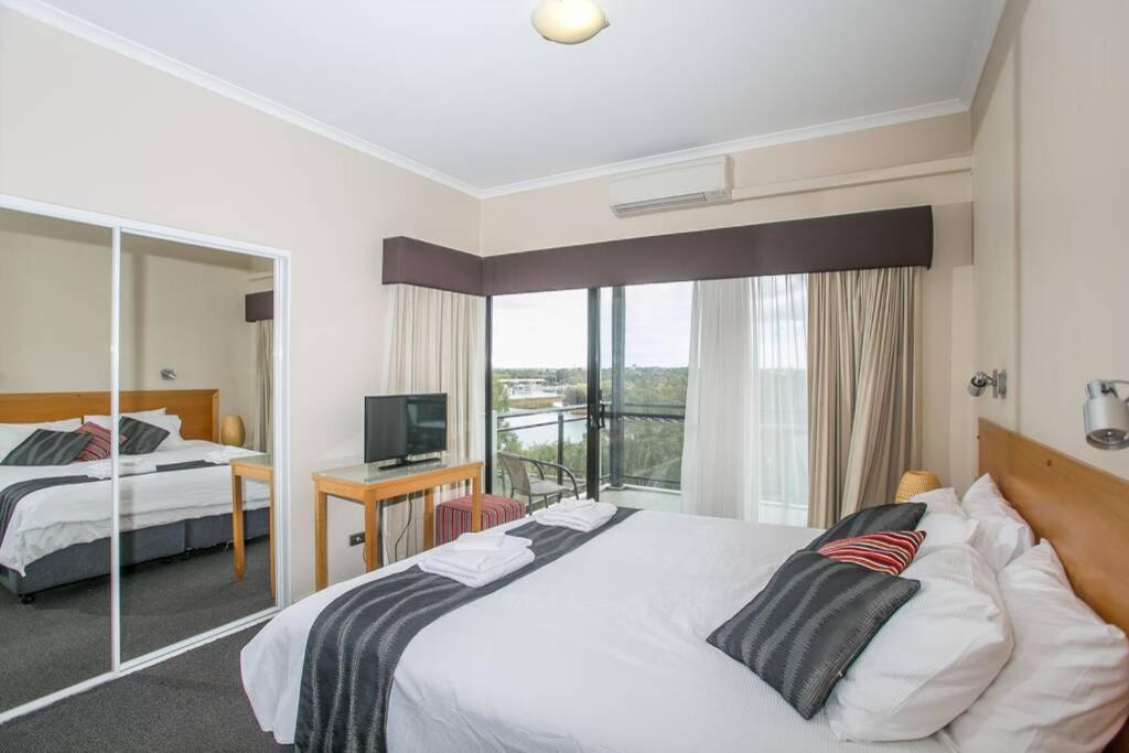 a hotel room with two beds and a balcony at Perth Ascot Sub Penthouse Spectacular 240 degree River and City Views , in Perth