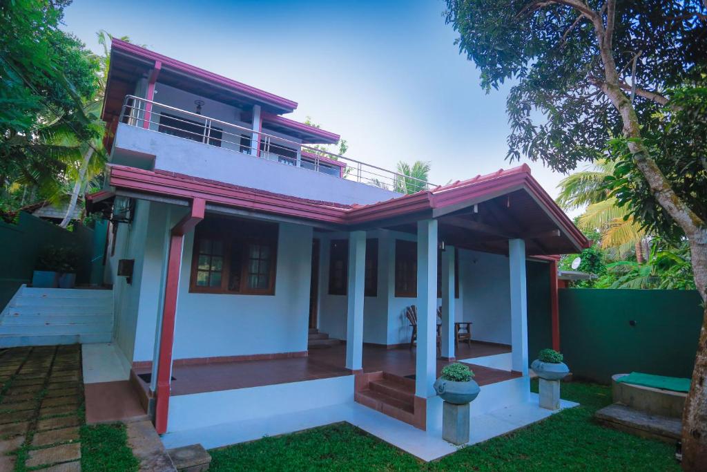 a white house with a red roof at Nimnada Villa in Galle