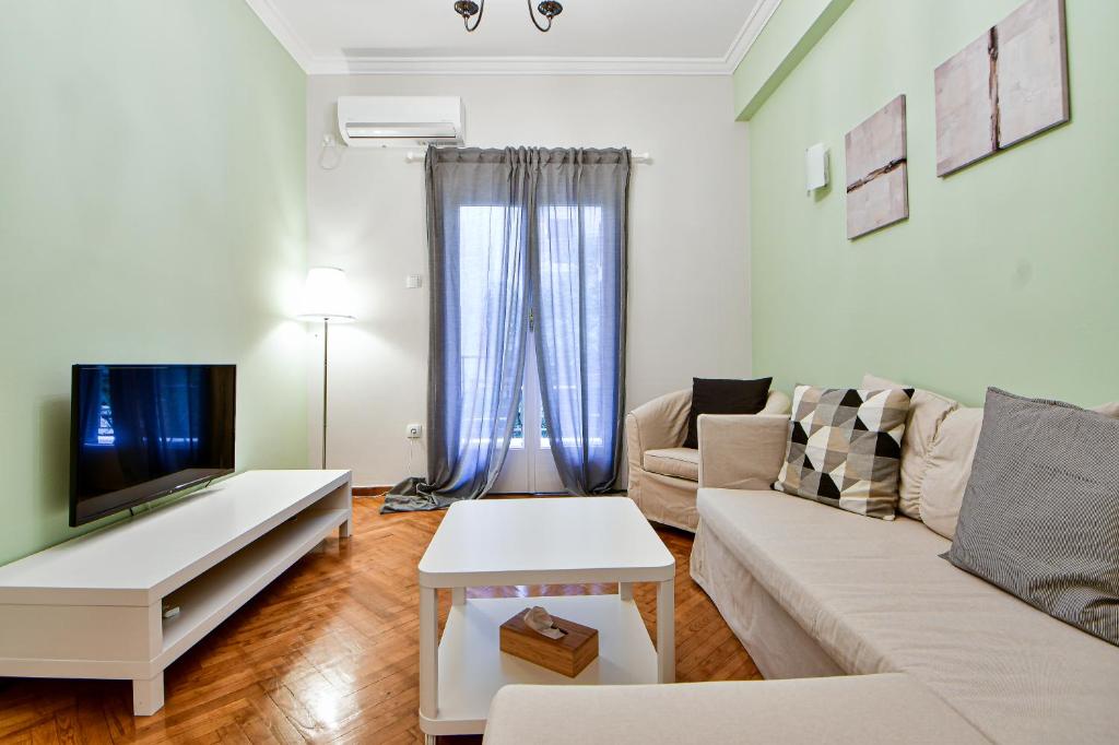 salon z kanapą i telewizorem w obiekcie Thiras Lovely Apartment BY ZAIN w Atenach