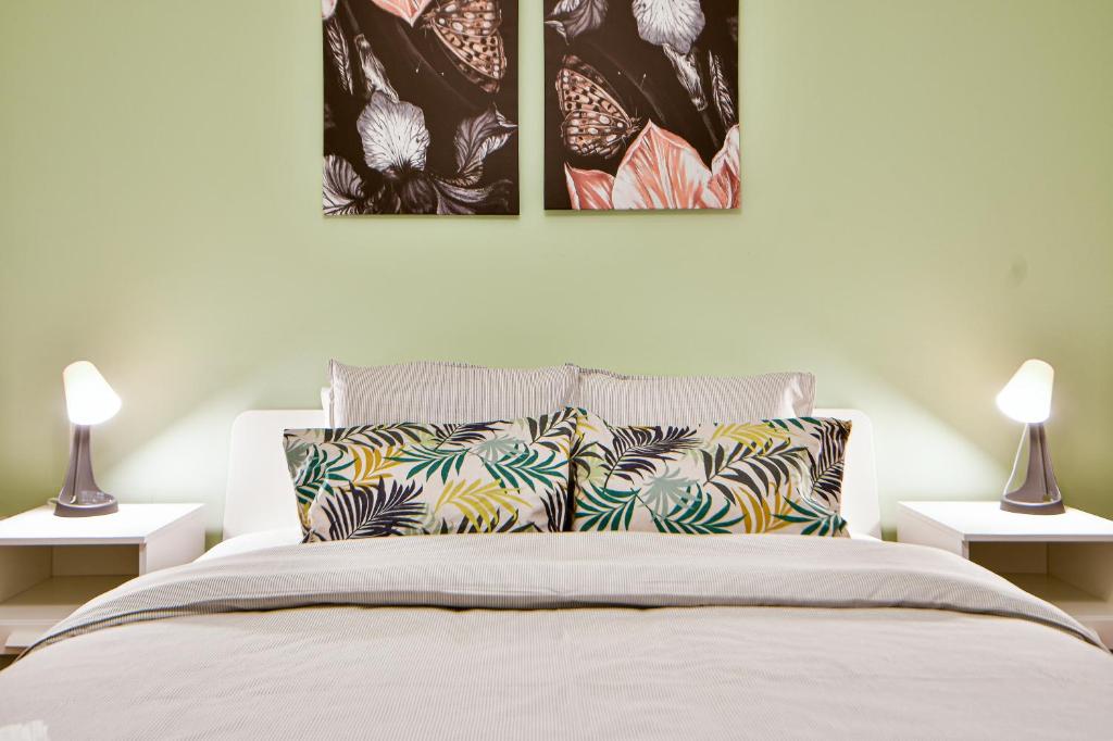 sypialnia z łóżkiem z trzema zdjęciami na ścianie w obiekcie Thiras Lovely Apartment BY ZAIN w Atenach