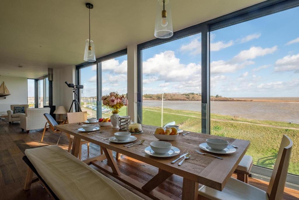 a dining room with a table and large windows at The Lookout in Felixstowe