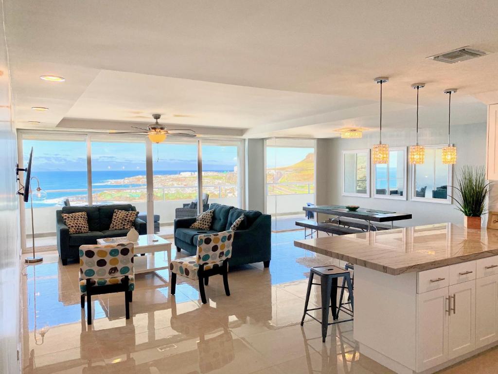 a kitchen and living room with a view of the ocean at BEACHFRONT CONDO w POOLS STEPS TO BEACH & MINS TO DT in Rosarito