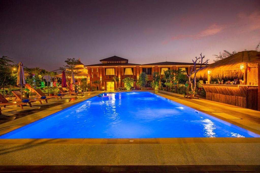 a large blue swimming pool in front of a house at Acacia Hotel Bagan in Bagan