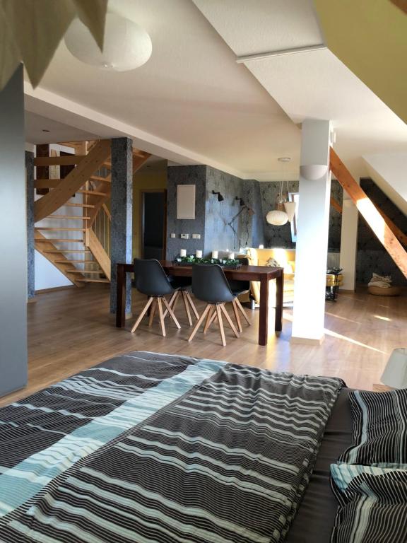 een woonkamer met een tafel en stoelen en een tapijt bij Maisonette Wohnung mit Blick über die Stadt in Jena