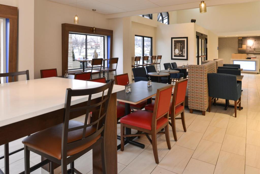 comedor con mesas y sillas en Holiday Inn Express & Suites Raleigh NE - Medical Ctr Area, an IHG Hotel en Raleigh