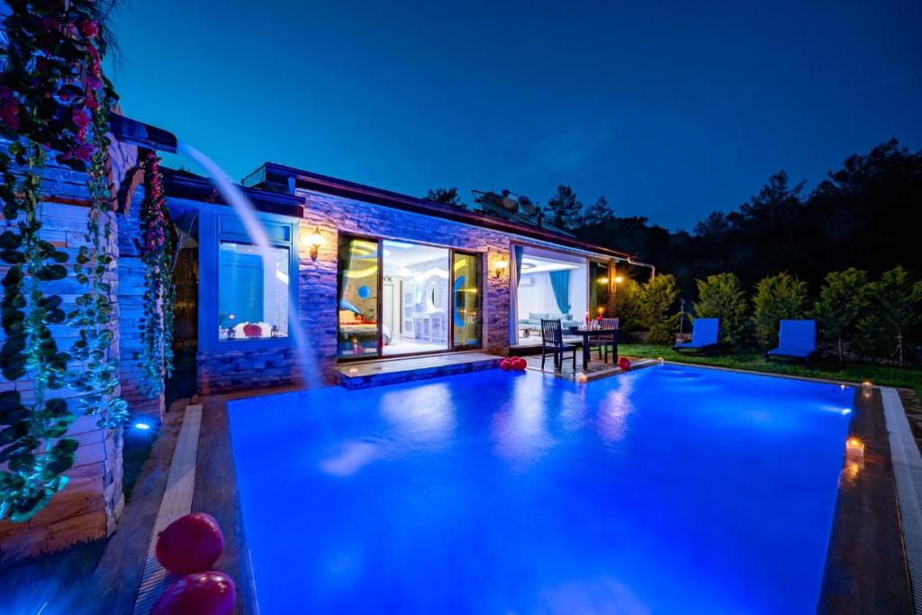 a swimming pool in front of a house at night at TERRA DORUK in Fethiye