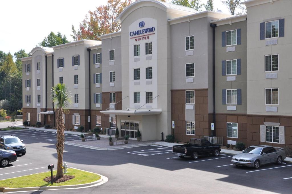 un grande edificio con auto parcheggiate in un parcheggio di Candlewood Suites - Mooresville Lake Norman, an IHG Hotel a Mooresville