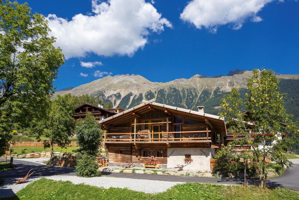 a log cabin with mountains in the background at Gratznhäusl in Ridanna