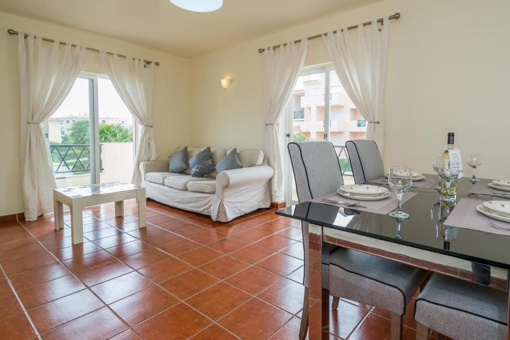 ein Wohnzimmer mit einem Tisch und einem Sofa in der Unterkunft Quinta do Paiva - Two Bedroom Apartment Olhos de Agua in Albufeira